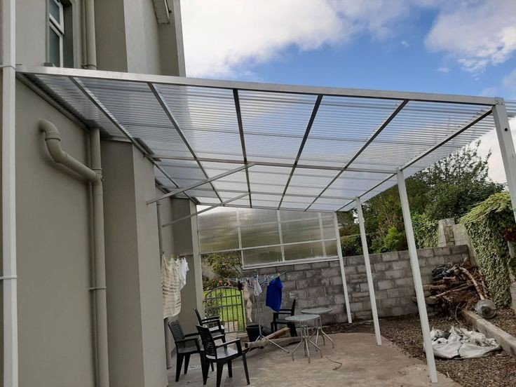 Steel-frame polycarbonate canopy over an outdoor seating area